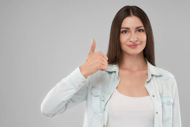 istock Smiling woman showing thumb up. 1204397018