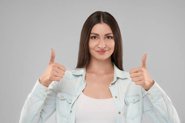 istock Smiling woman showing thumbs up. 1204397032
