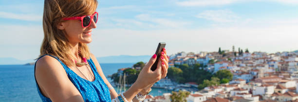 istock Young woman using cellphone above nice city panorama. 1204399812