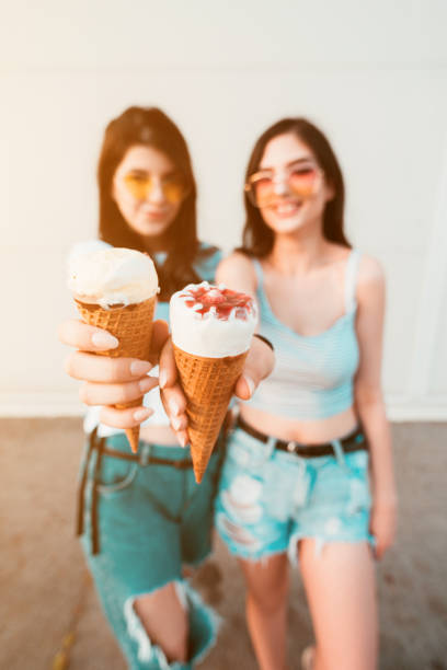 istock Two beautiful young women enjoying ice cream 1204399833