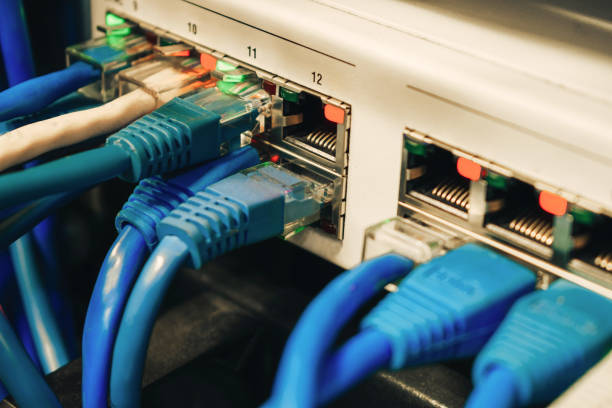 多くの通信インターネット ワイヤは、ネットワーク インターフェイスに接続されています。通信ケーブルはオフィススイッチのポートにあります。データセンターのサーバールームには青� - messy network server cable computer ストックフォトと画像