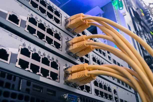 istock Technology concept. A bunch of yellow communication cables connect to the router interfaces. Telecommunication equipment is in the server room of the data center. 1204400862
