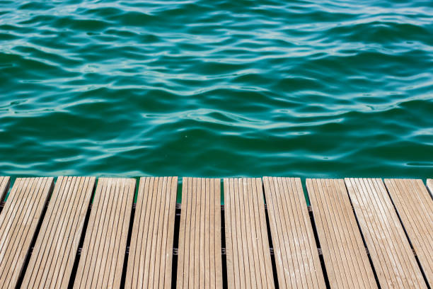 istock wooden deck floor waterfront shoreline background texture material perspective foreshortening surface to blue water, wallpaper pattern for copy or text 1204401210