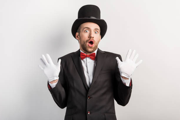 istock magician in gloves and hat with shrug gesture, isolated on grey 1204403038
