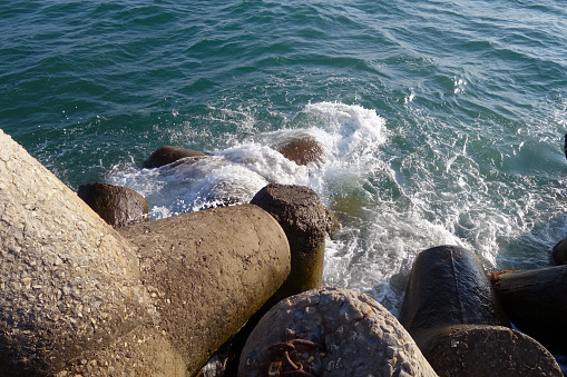 Breakwater stones on mole at Black sea. Sea view and background.
