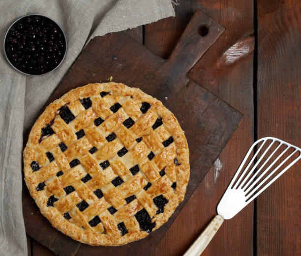 istock baked round black currant cake on an iron plate, top view 1204406498