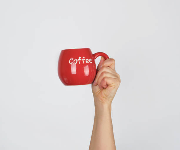 istock red ceramic cup in a female hand on a white background 1204407594