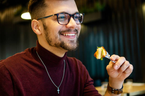 istock Young Man eating in Fast Food restaurant 1204407911