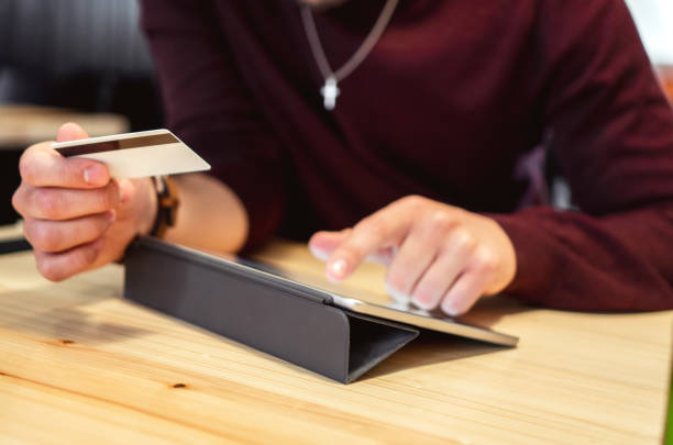istock A male hand holding credit card and typing on Digital Tablet 1204407961