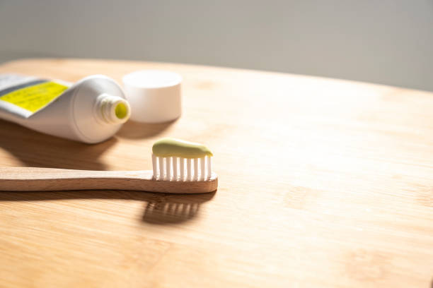 istock Close up of wooden toothbrush and toothpaste on bamboo background, zero waste concept 1204408076