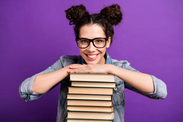 Photo of funny student lady holding many books carry literature home in love with reading wear specs casual denim outfit isolated purple color background Photo of funny student lady holding many books carry literature home in love with reading, wear specs casual denim outfit isolated purple color background topknot stock pictures, royalty-free photos & images