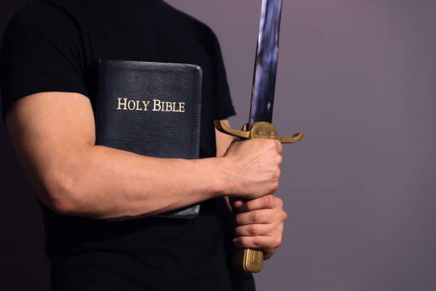 Young Athletic Man with His Bible and Sword Casually dressed strong young guy standing ready with his Bible and sword apostle worshipper photos stock pictures, royalty-free photos & images