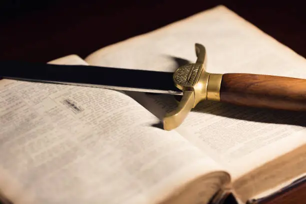 Ancient sword beside an open 150 Year Old Bible