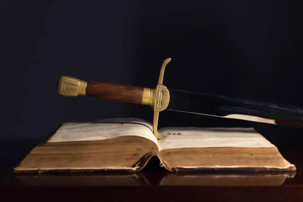 Ancient sword beside an open 150 Year Old Bible