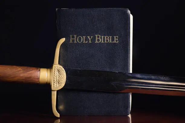 Old long sword beside the Holy Bible