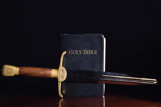 Old long sword beside the Holy Bible