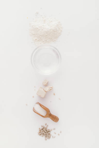 istock Baking cereal bread a Step by step guide to bake cereal bread,  top view on a white board, ingredients line up vetically. 1204415846