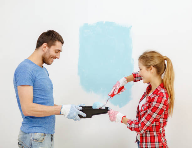 istock smiling couple painting wall at home 1204415892