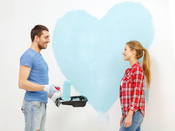 istock smiling couple painting big heart on wall 1204416163