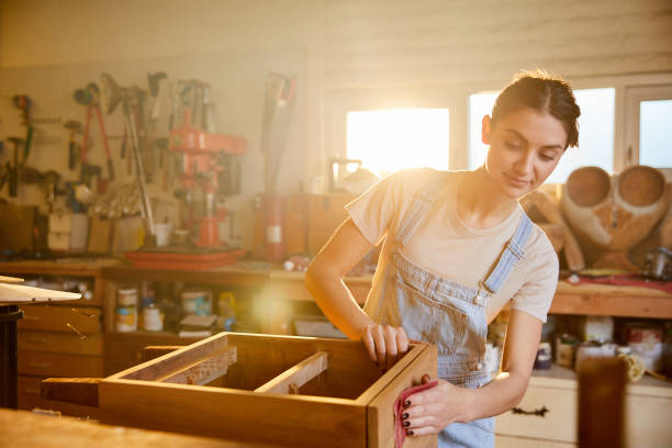 istock Smiling woman sanding on some drawers in her carpentry studio 1204416869