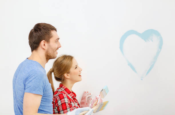 istock smiling couple painting small heart on wall 1204416871