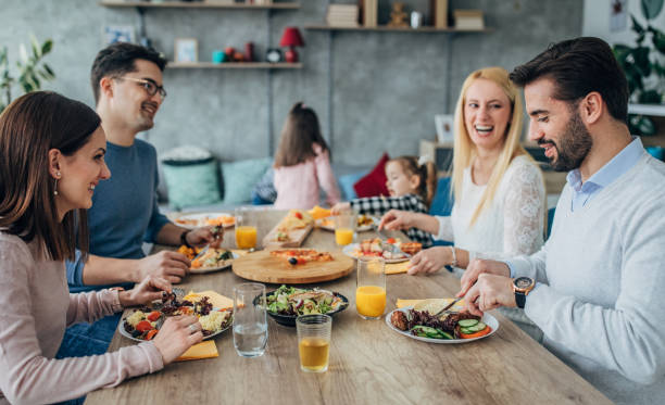 istock Two families having lunch together at home 1204417119