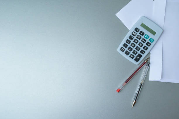 Empty white letter envelope, pens and calculator