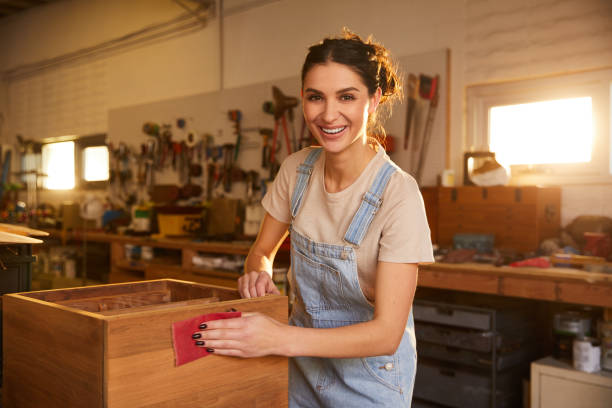 istock Smiling young woman working in her carpentry workshop 1204419624