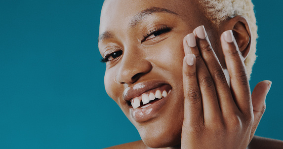 Cropped shot of a beautiful young woman applying moisturizer to her face