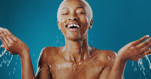 Cropped shot of a beautiful young woman splashing water over her face