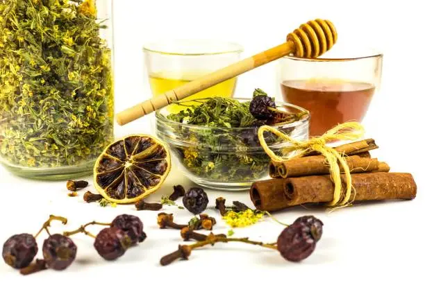 Medicinal herbal tea with honey on white background. Traditional treatment of flu and cold. Alternative medicine. Medicinal herbs.