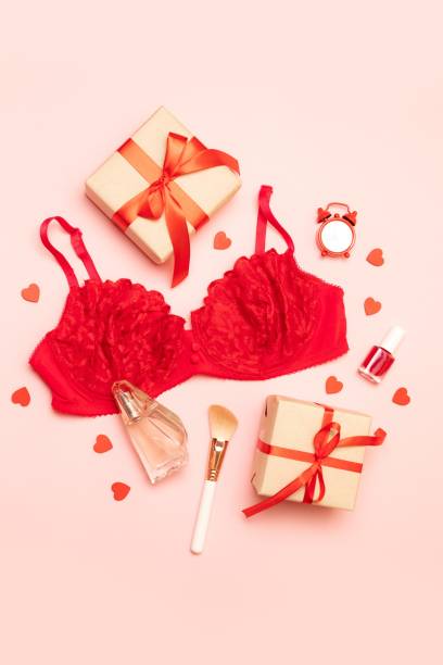 creative composition of red lace bra, perfume, gifts boxes and cosmetics brush on a pink background - panties lingerie sensuality bra imagens e fotografias de stock