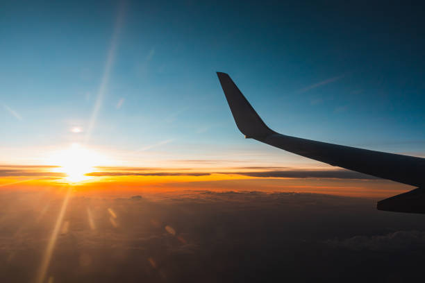 istock Airplane flying above the clouds at sunset. 1204423294
