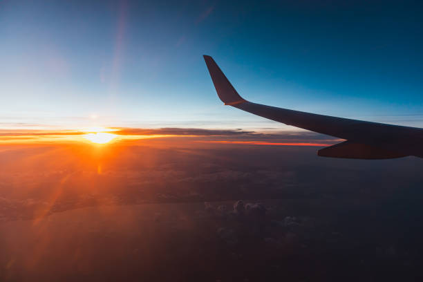 istock Airplane flying above the clouds at sunset. 1204423297