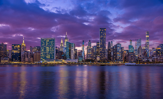 New York City Skyline with UN Building, Chrysler Building, Empire State Building and East River at Sunset.