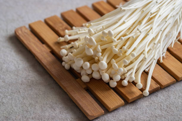 seta enoki, seta de aguja dorada en tabla de madera - edible mushroom plants raw food nature fotografías e imágenes de stock