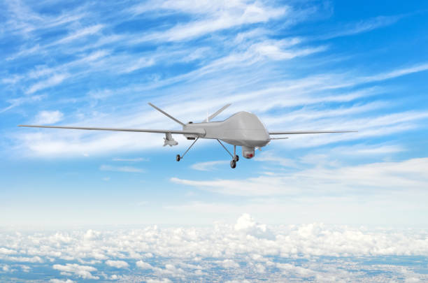 istock Military uav drone flight flies above the clouds. 1204426212