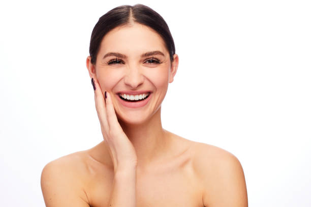 istock Young woman touching her soft cheek on a white background 1204426240