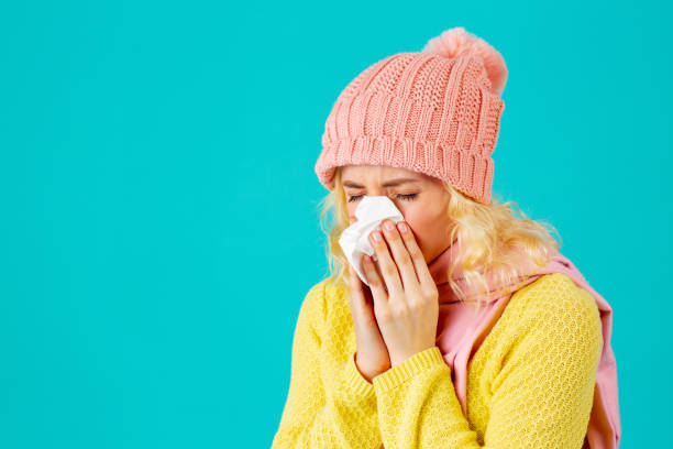 감기와 독감 시즌 - 모자와 스카프에 여자의 초상화는 그녀의 코를 불고 - kleenex yellow white pink 뉴스 사진 이미지