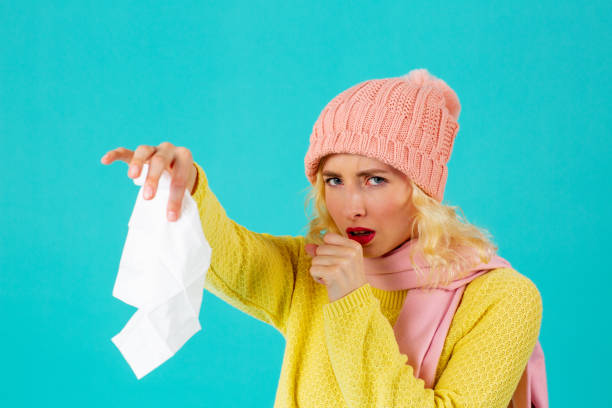 감기와 독감 시즌 - 모자와 스카프 기침과 홀핑 조직에 여자의 초상화, 파란색에 고립 - kleenex yellow white pink 뉴스 사진 이미지
