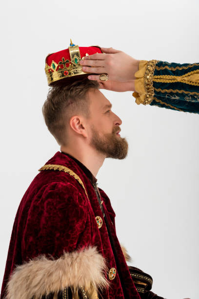 cropped view of man putting crown on king on grey background cropped view of man putting crown on king on grey background coronation photos stock pictures, royalty-free photos & images