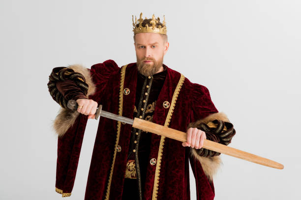 istock serious king with crown holding sword isolated on grey 1204426880