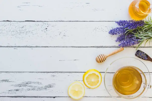 Photo of Lavender tea with a jar of honey, honey dipper,  lemon  (Flat lay)