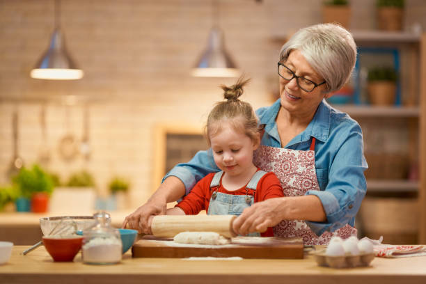 domowe jedzenie i mały pomocnik - grandmother pie cooking baking zdjęcia i obrazy z banku zdjęć