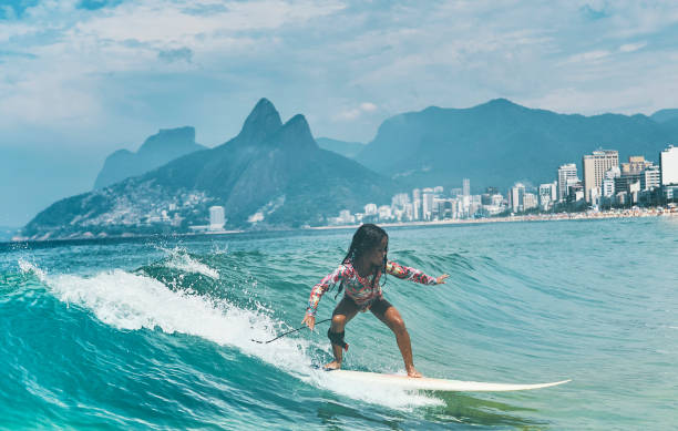 istock Beautiful little surfer rides on surfboard 1204429367