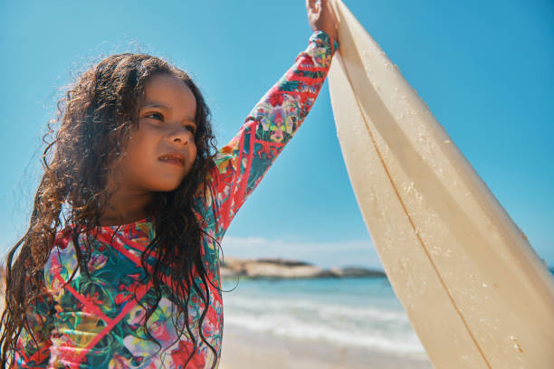 istock Beautiful little surfer on the beach 1204429369