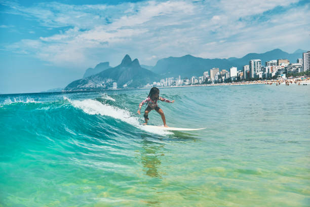 istock Beautiful little surfer rides on surfboard 1204429446