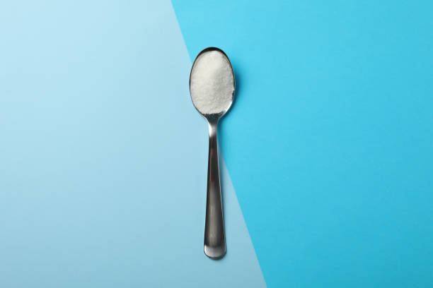 spoon with sugar on two tone background, space for text - sugar spoonful imagens e fotografias de stock