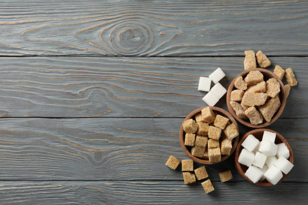 istock Bowls with different sugar on wooden background, top view 1204432988