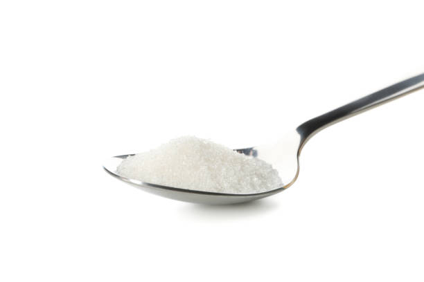 istock Spoon with sugar isolated on white background, close up 1204433125